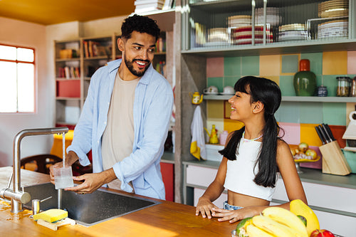 Father and daughter bonding in the kitchen while preparing for a meal