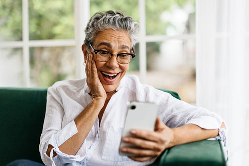 Happy senior woman enjoying a leisurely video call at home