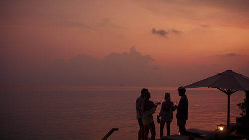 Friends gather at sunset on a luxurious resort deck