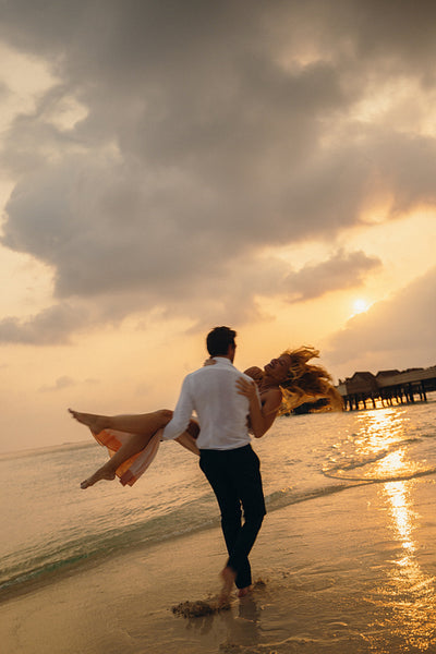 Romantic married couple enjoying a sunset moment on a beautiful island beach