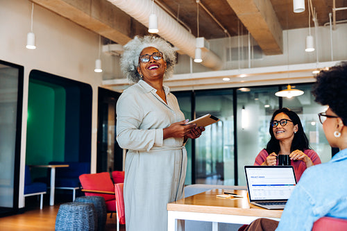 Confidence in experience: Mature leader with tablet in modern workspace