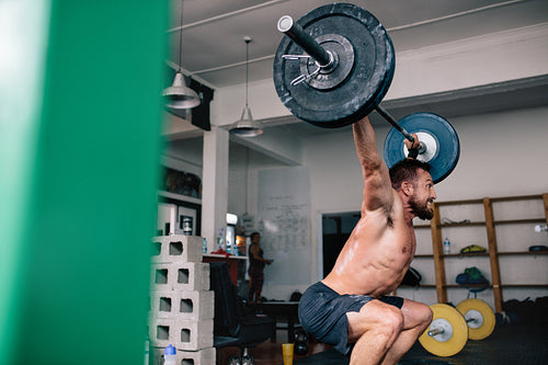 Strong athlete exercising with heavy weights