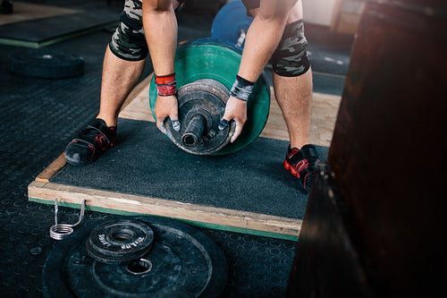 Muscular man exercising with heavy weights in gym