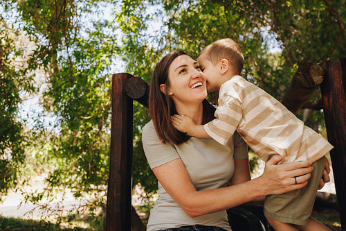 Loving moment as mother and child share a secret under nature's embrace