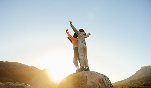 Two people celebrating on a rock