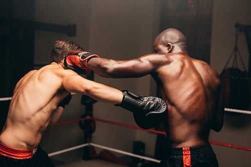 Two boxers fighting in a boxing ring