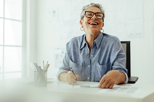 Female design expert laughing happily in her office