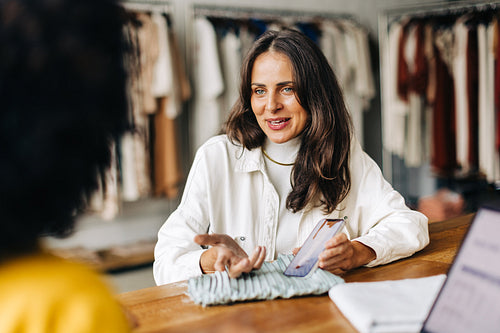 Clothing designer showing a client her recent designs on a smartphone