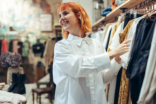 Attractive woman choosing clothes in store