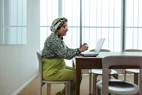 Businesswoman engaging in a discussion via video call in a bright office setting