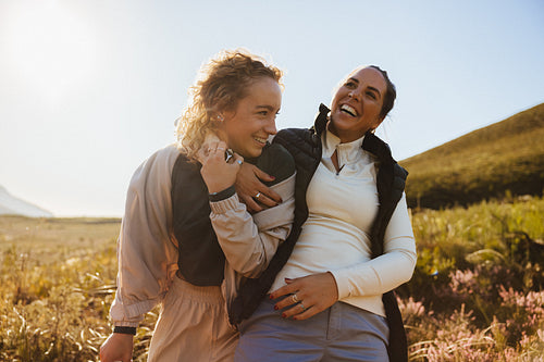 Two friends laughing in a meadow