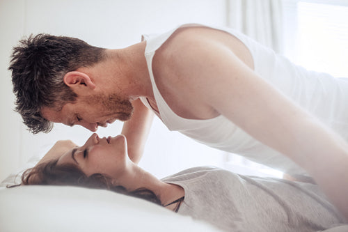 Intimate young couple during foreplay in bed