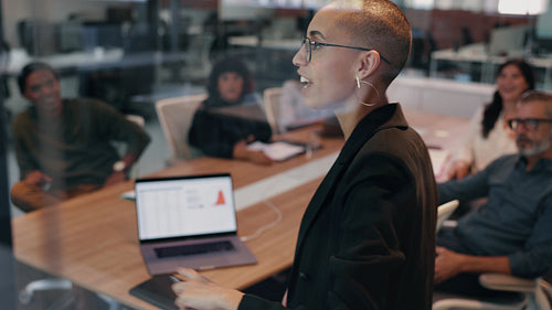 Young female professional giving a speech in an office, addressing her team during a meeting