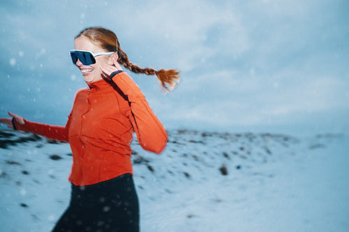 Woman running outdoors in winter snow for fitness training