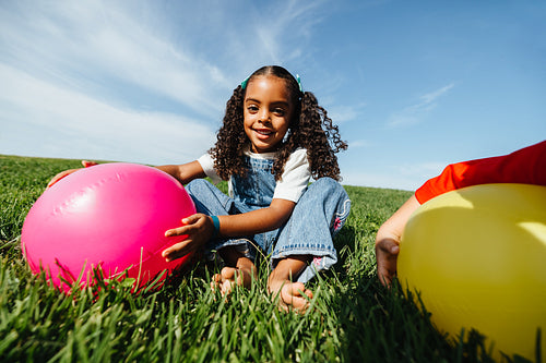 Girl enjoying playful summer moment with ball outdoors