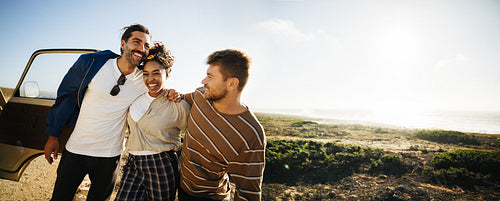 Three friends enjoy a sunny coastal road trip adventure by the sea
