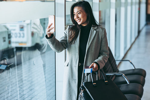 Female traveler taking selfie at airport terminal
