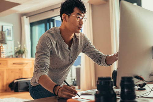 Photographer editing sample photos on his computer