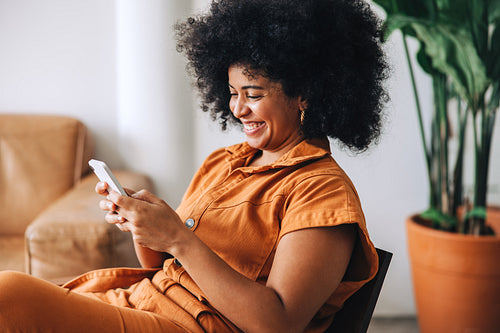 Happy businesswoman smiling while reading a text message in an office