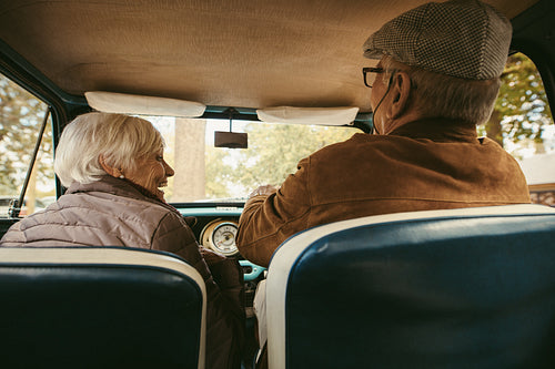 Old couple driving a car on a winter day
