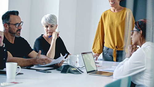 Business professionals discussing a report in the meeting