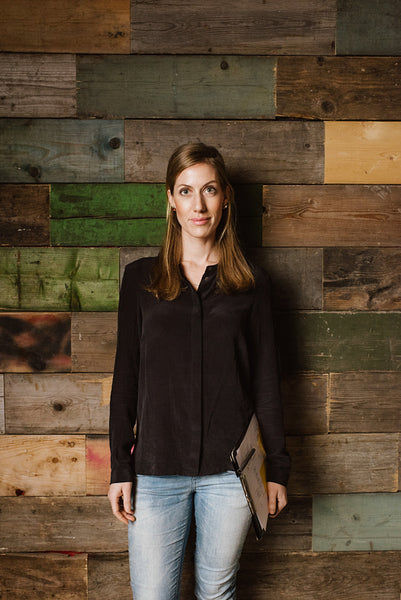 Beautiful young businesswoman standing against a wooden wall 
