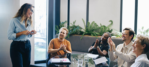 Diverse business people applauding their project manager after her presentation