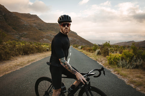 Cyclist taking break on country highway