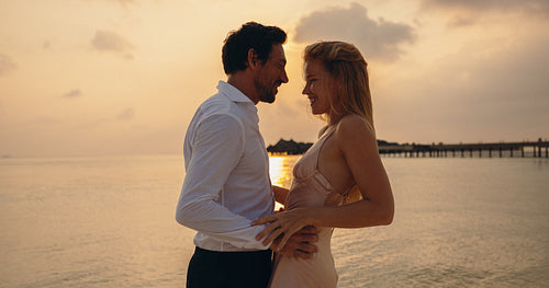 Romantic couple sharing a special moment during a luxurious tropical vacation at sunset