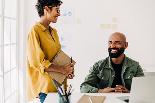 Two designers laugh together as they have a discussion
