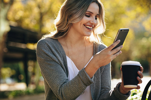 Woman sitting outdoors using cell phone