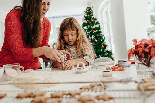 Mother and daughter preparing Christmas cookies.