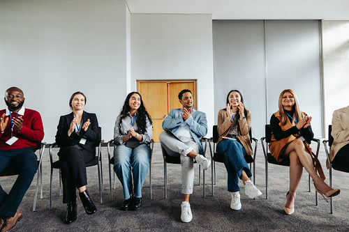 Shared enthusiasm: Diverse professionals applauding at a corporate workshop.