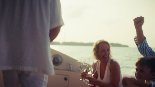 Happy multi generational family toast aboard a luxury boat during golden hour