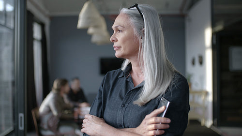 Smiling senior businesswoman at office looking around