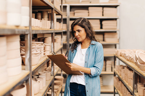 Young ceramist taking stock in her shop