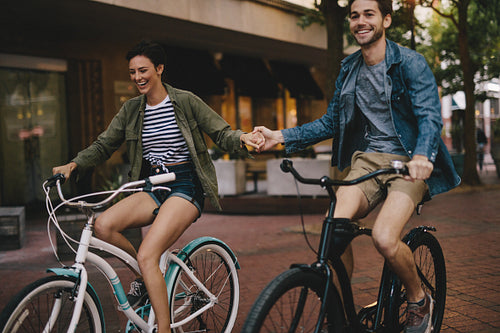 Happy couple cycling in the city
