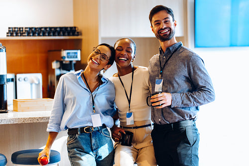 Group of colleagues smiling together during a casual break in the office