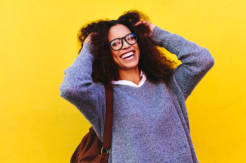 Cheerful female traveler on yellow background