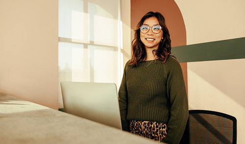 Happy receptionist standing at the front desk