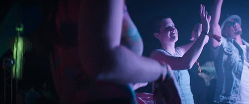 Young adult man smiles at a music festival while dancing to music