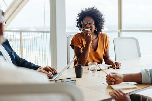 Professional businesswoman engaged in a creative brainstorming session with her team in a modern office