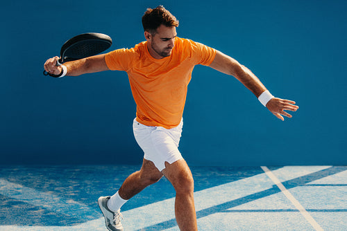 Young athlete hitting a forehand in a padel championship match