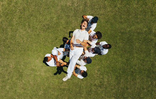 Players tossing a cricket teammate in celebration on the field