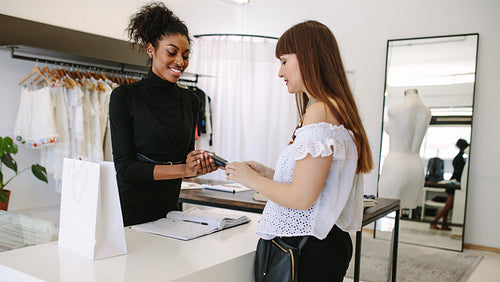 Woman entrepreneur making sale in her fashion studio