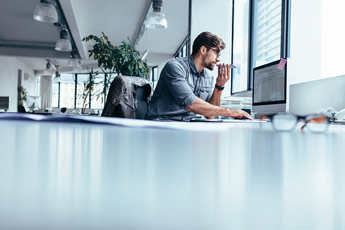 Businessman working in office with phone