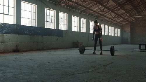 Muscular woman doing the deadlift workout in gym