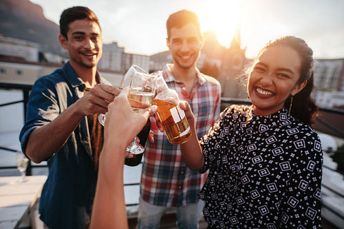 Young people at party toasting beers