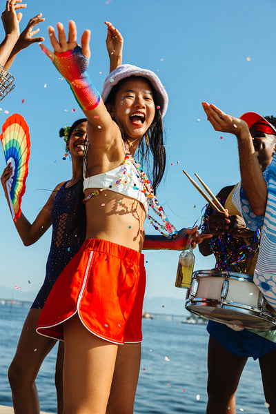 Carnival party on the beach with dancing friends