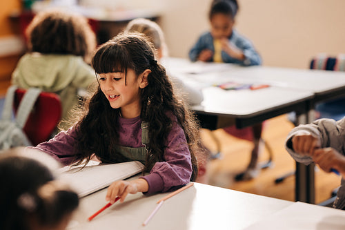 Female elementary school student sitting at her desk and doing her school work